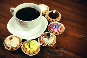 Nahaufnahme einer kleinen Tasse Kaffee mit bunten Cupcakes foto
