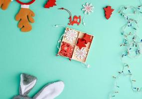 brennende weihnachtsgirlande auf einem weißen draht mit bunten lichtern und kiste mit holzspielzeug für den weihnachtsbaum foto