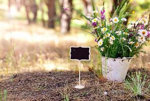 leere hölzerne Tafel auf dem Hintergrund eines Blumenstraußes foto