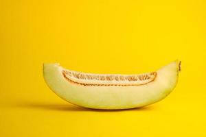 Stück reife Melone mit Samen auf gelbem Hintergrund foto