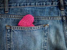 rotes gestricktes Herz in der Gesäßtasche der Jeans foto