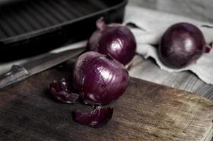 rote Zwiebel auf einem Küchenschneidebrett foto