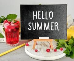 Schwarze Kreidetafel zum Schreiben eines Sommergetränkerezepts und eines Glases mit Beerenlimonade foto