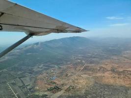 Blick aus einem Flugzeug auf die Tragfläche und die Savanne in Kenia darunter. foto