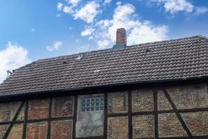 altes Dach mit schwarzen Dachziegeln mit Fachwerkwänden. foto