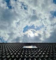 offenes dachfenster im velux-stil mit umlaufenden schwarzen dachziegeln foto