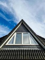 offenes dachfenster im velux-stil mit schwarzen dachziegeln. foto