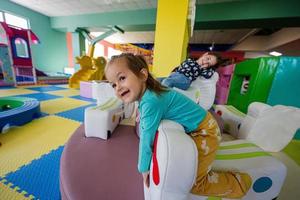 glückliche Schwestern, die auf dem Spielplatz im Indoor-Spielzentrum spielen. foto