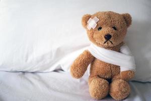 Teddybär und Verband. Verletzungskonzept foto