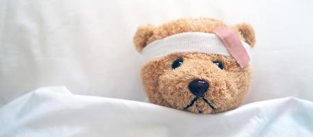 Teddybär und Verband. Verletzungskonzept foto