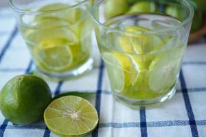 geschnittene Zitrone und Zitronensaft in einem Glas eingeweicht foto