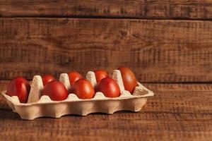 mit natürlichen umweltfreundlichen farben gefärbte ostereier, zwiebelschalen in einer eierschachtel auf holzhintergrund. osterfeier minimalkonzept umweltfreundliche haltung, feiertagssymbol, kopierraum foto