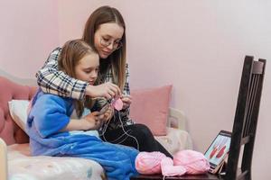 familienfreizeit für handarbeit, mutter und tochter stricken herzen aus rosa garn foto