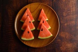 Wassermelone in Stücke geschnitten auf einem Holztisch foto