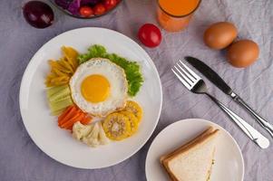 Spiegelei-Frühstück mit Gemüse und Saft foto