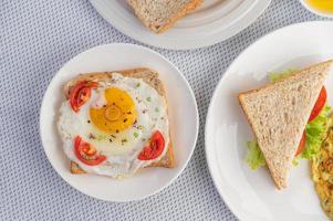 Omeletts mit Spiegelei und einem Tomatensandwich foto