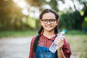 Mädchen hält eine Plastikflasche foto