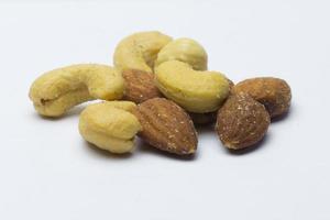 getrocknete gesalzene Cashewnüsse und Mandeln auf weißem Grund foto