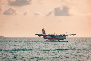 08.09.2019 - ari atoll, malediven exotische szene mit wasserflugzeug auf malediven seelandung. Wasserflugzeugtaxi auf dem Meer bei Sonnenuntergang vor dem Start. urlaub oder urlaub auf den malediven konzepthintergrund. Lufttransport foto