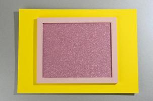 rosa glänzender rechteckiger Rahmen auf grau-gelbem Hintergrund mit Schatten foto