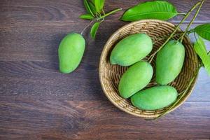 frische grüne Mangofrucht in einem Holzkorb foto