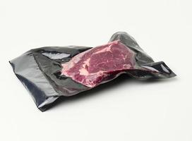 Stück frisches Rindfleisch, verpackt in einem Vakuum-Plastikbeutel, Ansicht von oben foto