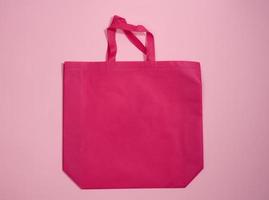 leere Viskose-Umhängetasche aus umweltfreundlichem rosafarbenem Segeltuch für das Branding auf rosafarbenem Hintergrund. klare wiederverwendbare tasche für lebensmittel, mock up foto