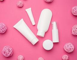 glas, flasche und leere weiße plastikrohre für kosmetik auf rosa hintergrund. Verpackung für Creme, Gel, Serum, Werbung und Produktwerbung, Attrappe foto