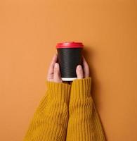 hand hält papierkarton braune tasse für kaffee. umweltfreundliches Geschirr foto