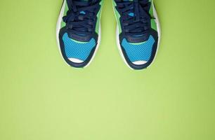 Paar blaue Textilturnschuhe auf grünem Hintergrund, Ansicht von oben. Schuhe für den Sport foto