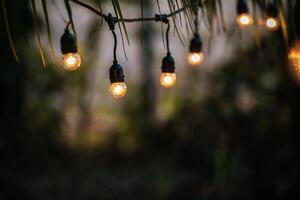 leuchtende Glühlampen hängen in Form einer Girlande. weihnachtliche warme goldgirlandenlichter. Festival-Event-Party. Girlanden, heller Weihnachtsdekorationshintergrund. party- und feierkonzept. foto