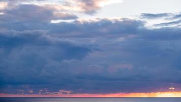 orange, lila landschaftsorientiertes Sonnenuntergangsbild am Horizont foto