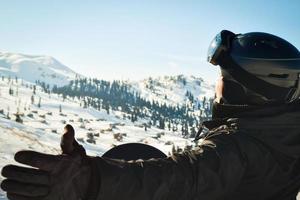 männliche Person allein im Winter-Ski-Outfit genießt Panorama der Berge mit gespreizten Händen. snowboard im wald und im kaukasus foto