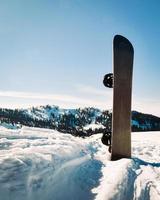 Snowboard gegen blauen Himmel und schneebedeckte Berge in Europa, Kaukasus foto