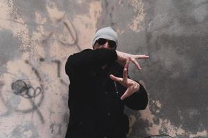 reifer mann rap-sänger posiert auf der straße am rande einer stadt foto