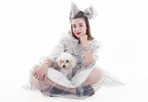Porträt eines hübschen Mädchens in lustiger Kleidung und ihres kleinen Hundes foto