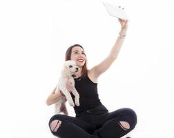 hübsches Mädchen macht ein Selfie mit seinem Hund auf weißem Hintergrund foto