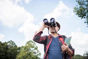 junger Mann mit Fernglas im Wald foto