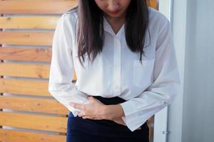 berufstätige Frauen mittleren Alters haben Bauchschmerzen wie Verdauungsstörungen. gestroösophageale Refluxkrankheit foto