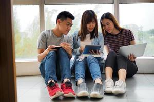 Studentengruppen sehen sich Informationen in Büchern, Tablets und Laptops an. gerne zusammen lernen foto