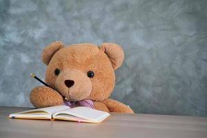 Der Teddybär schreibt ein Buch. Lernen von Kindern foto