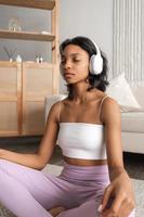 Vertikales Banner mit Seitenansicht Porträt einer ruhigen schwarzen Frau mit Kopfhörern, die meditiert und entspannende Musik hört foto
