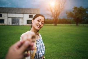 Frau geht und hält die Hand ihres Freundes, der ihr folgt foto