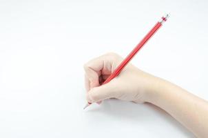 Frauenhand mit rotem Bleistift auf weißem Hintergrund foto