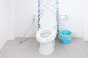 toilettenschüssel in einem modernen badezimmer und blauen mülleimern, spültoilette weiß im badezimmer foto