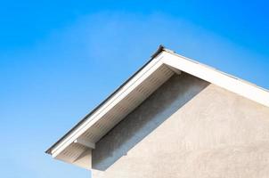 Hausdach mit blauem Himmel, allgemeiner Blick auf die Fassade eines neuen Hauses mit blauem Himmel im Hintergrund foto