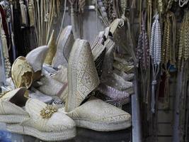 braut festliche schuhe bunte handgefertigte lederpantoffeln warten auf kunden im shop in fes, neben gerbereien, marokko foto