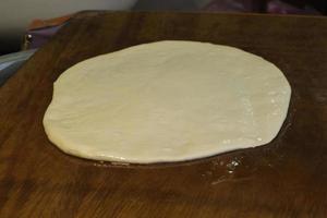 frau knetet teig auf einem öligen tisch und kocht traditionelles rghayf oder msemen, ein traditionelles marokkanisches brot in der medina von fes foto