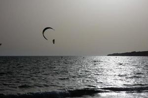 Windsurfen, Kitesurfen, Wasser- und Windsport mit Segeln oder Drachen foto