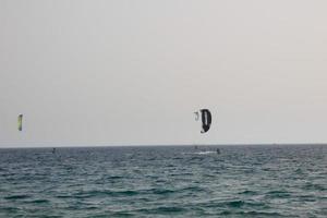 Windsurfen, Kitesurfen, Wasser- und Windsport mit Segeln oder Drachen foto